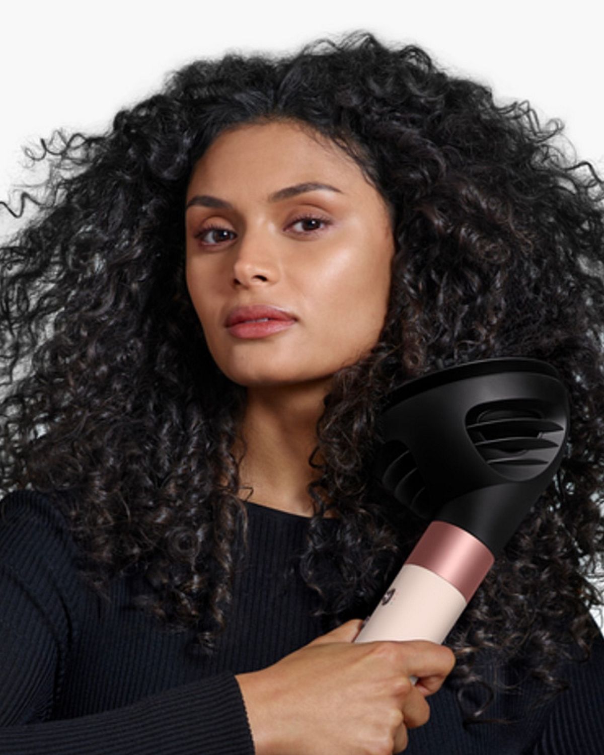 Model holding the Dyson Airwrap ID multi-styler and dryer with the Diffuser.